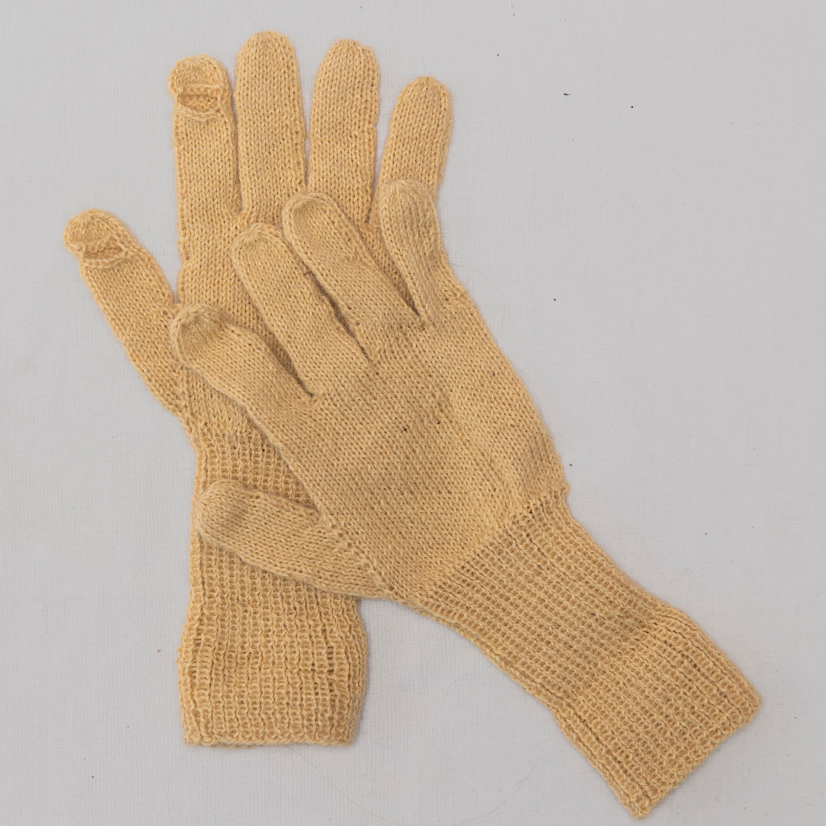 A pair of light tan knit gloves with ribbed cuffs,