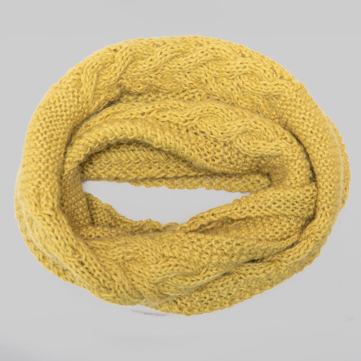 A mustard yellow cable-knit infinity scarf