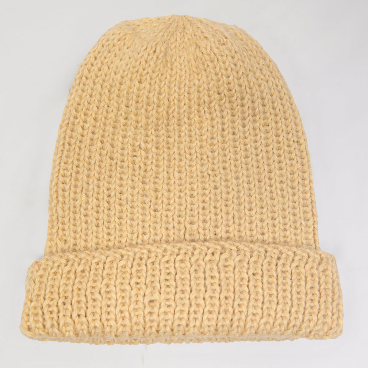 A light beige knit beanie hat with a folded cuff,