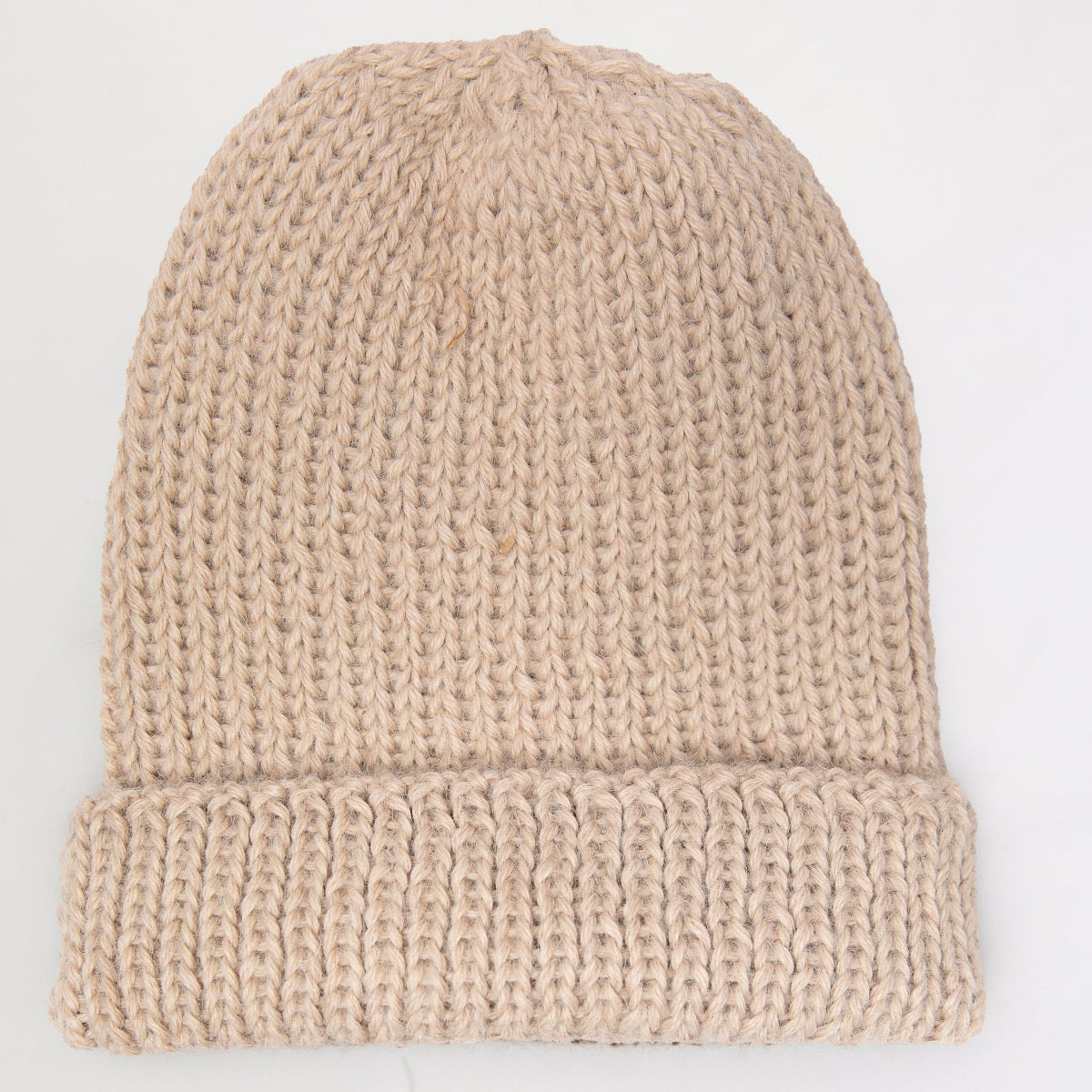 A beige chunky knit beanie hat with a folded cuff.